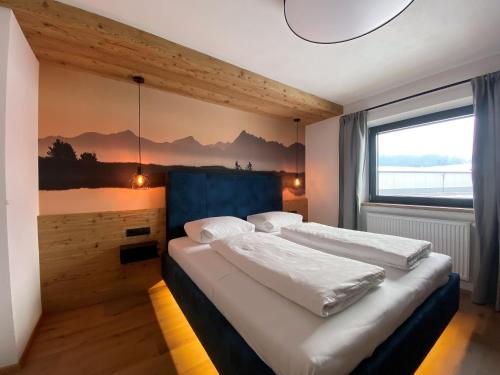 a bedroom with a large bed and a large window at Landhaus Rohrmoser in Zell am Ziller