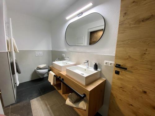 ein Bad mit einem Waschbecken und einem Spiegel in der Unterkunft Landhaus Rohrmoser in Zell am Ziller