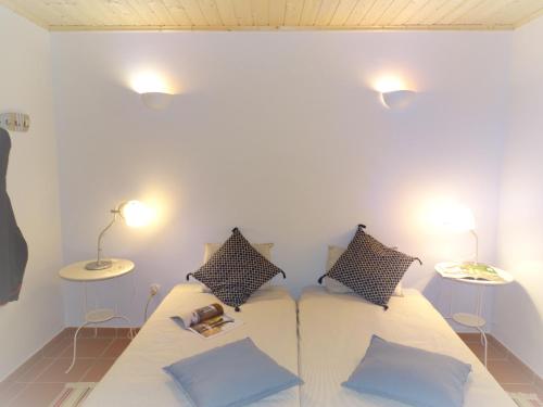 - une chambre avec un lit avec des oreillers et 2 tables dans l'établissement QUINTA DAS TEIMOSAS by Stay in Alentejo, à Cercal