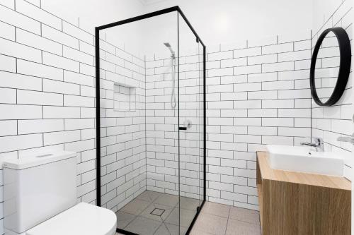 a bathroom with a toilet and a glass shower at Grand Terminus Hotel in Bairnsdale