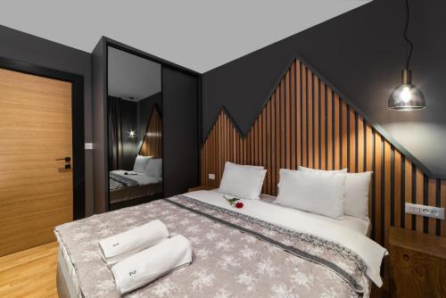 a bedroom with a large bed with white pillows at Modern Mountain La Stella in Kolašin