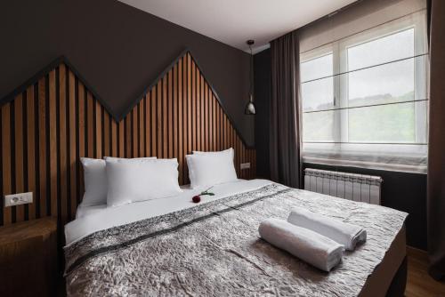 a bedroom with a large bed with two towels on it at Modern Mountain La Stella in Kolašin