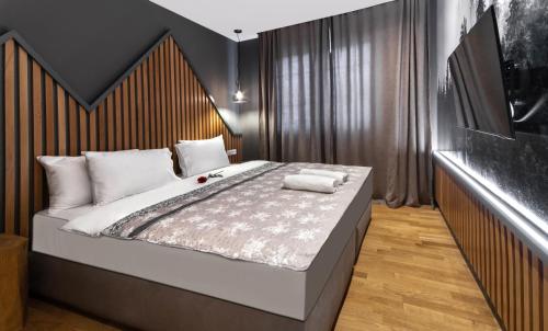 a bedroom with a large bed with a wooden headboard at Modern Mountain La Stella in Kolašin