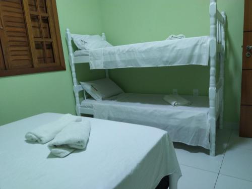 a room with two bunk beds with towels on them at Casa com piscina - Prado in Prado