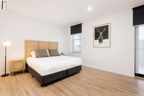 a bedroom with a bed in a white room at Grand Terminus Hotel in Bairnsdale