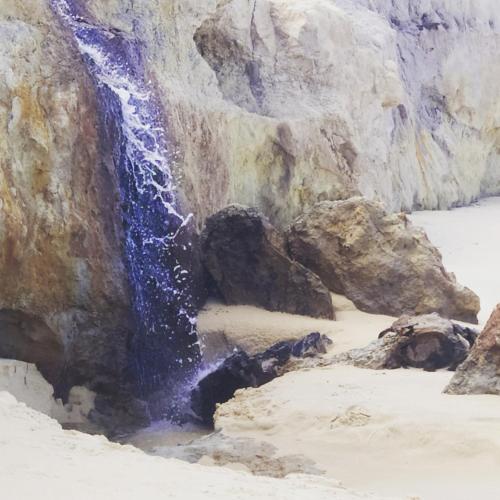 a painting of a waterfall on a beach at Casa com piscina - Prado in Prado