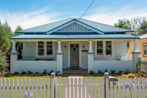 a white house with a fence in front of it at Sunny Federation Charm in Central Mudgee at Bunbinya in Mudgee