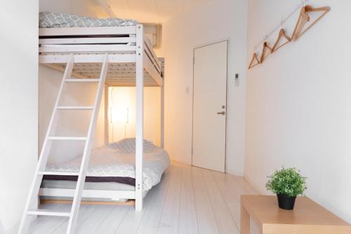 a bunk bed in a small room with a ladder at Casa Blanca Guesthouse in Nagasaki