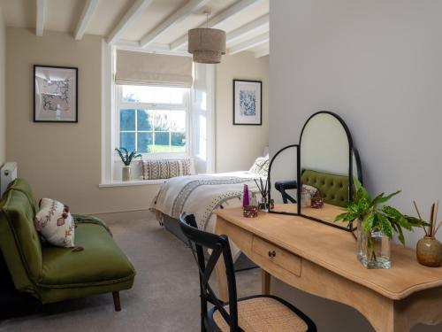 Bennar Fawr في Dyffryn: غرفة نوم بسرير ومكتب وطاولة