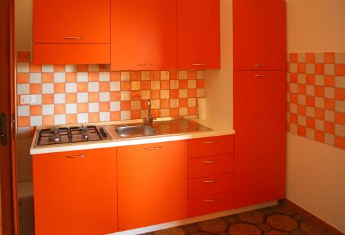 a kitchen with orange cabinets and a sink at Villa Mele in Lido Marini