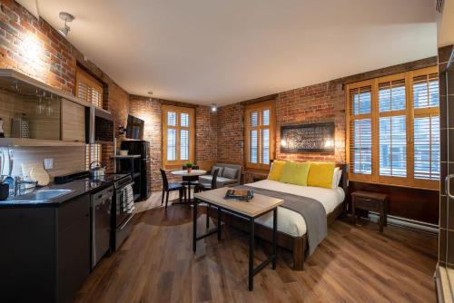 a room with a bed, a desk, and a tv at Appart-Hôtel Le Vincent in Quebec City