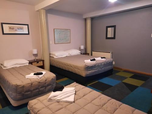 um quarto de hotel com duas camas e um tapete em Mountain House em Arthur's Pass
