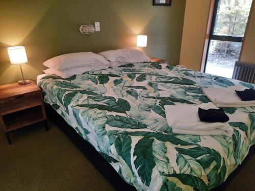 a bedroom with a bed with towels on it at Mountain House in Arthur's Pass