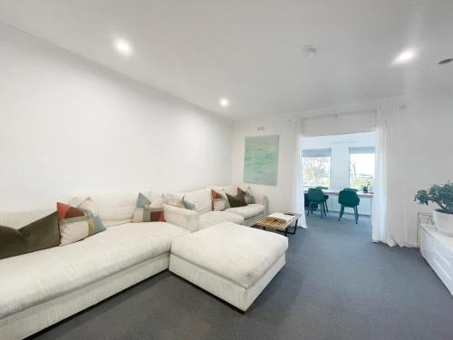 a white living room with a white couch and a table at Rye Pier Apartment in Rye