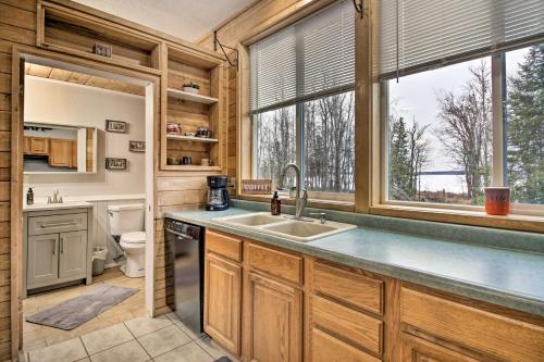 una cucina con lavandino, servizi igienici e finestra di Quiet Lakefront Grand Rapids Cabin on 5 Acres a Grand Rapids