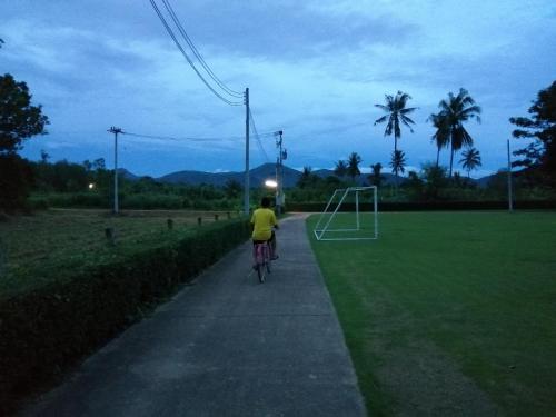a person riding a bike down a sidewalk at Vimannam Resort in Phetchaburi