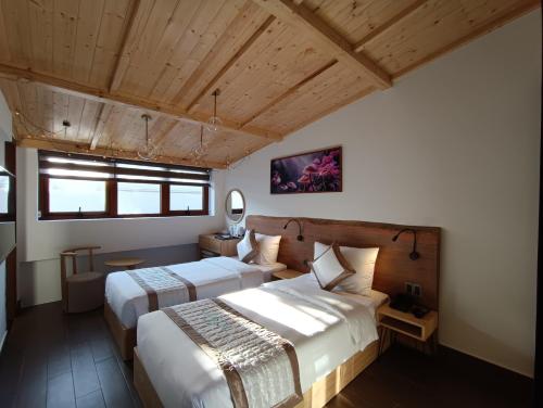 two beds in a room with wooden ceilings at Lasol Boutique Hotel in Da Lat
