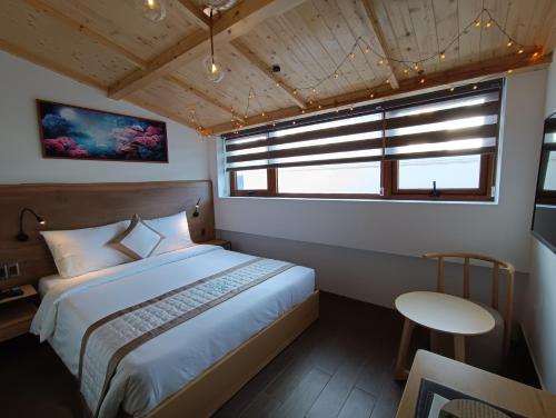 a bedroom with a bed and a table and a window at Lasol Boutique Hotel in Da Lat