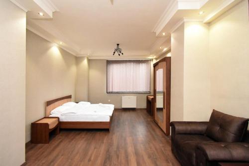 Malibu في يريفان: غرفة نوم بها سرير وأريكة