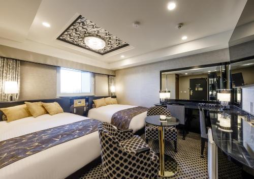 una camera d'albergo con 2 letti e una scrivania di APA Hotel Hakata Gion Ekimae a Fukuoka