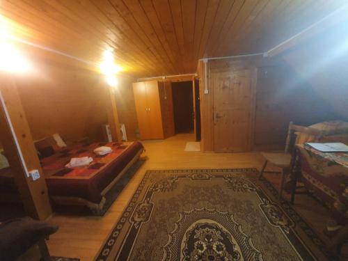 a room with a bed and a rug in a room at Pensiunea Casa Motilor in Bucium