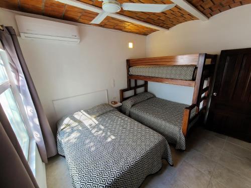 Cette petite chambre comprend des lits superposés et une chaise. dans l'établissement Madre Cuixe Suites, à La Peñita de Jaltemba