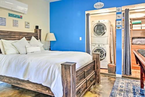 1 dormitorio azul con 1 cama y lavadora en Albuquerque Studio with Shared Pool and Fire Pit!, en Albuquerque