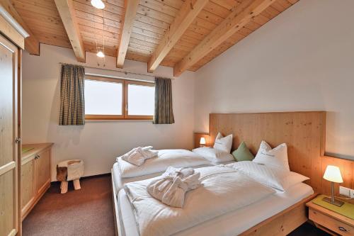 a bedroom with a large bed with white sheets at Appartement Omesberg 1 in Lech am Arlberg