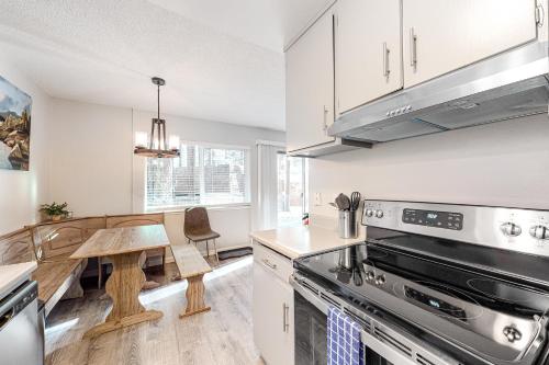a kitchen with a stove top oven next to a table at North Tahoe Nest in Incline Village