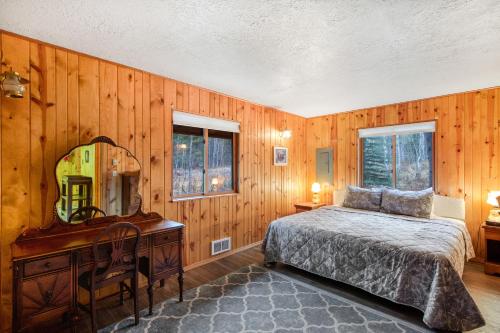 a bedroom with a bed and a desk and a mirror at The Legacy in McCall