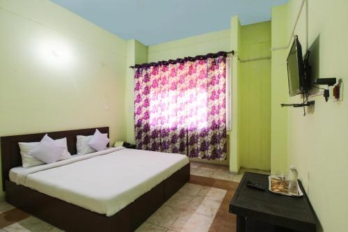 a bedroom with a large bed and a window at Hotel Pinjore Holiday Home in Pinjaur