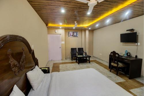 a bedroom with a bed and a desk and a television at Hotel Pinjore Holiday Home in Pinjaur