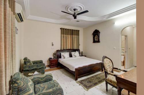 a bedroom with a bed and a table and chairs at Hotel Pinjore Holiday Home in Pinjaur