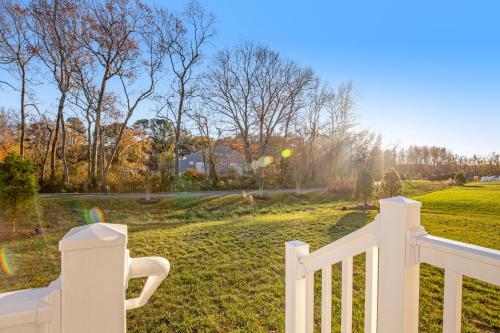 a white fence in front of a yard with trees at Millville by the Sea- 23923 Pembroke Lane in Millville