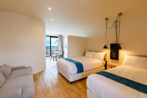 a hotel room with two beds and a couch at Blue Steak Wonder Chatan in Chatan