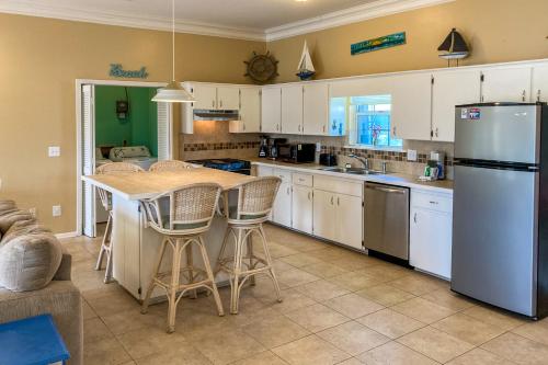 a kitchen with white cabinets and a table and chairs at Weatherbee by the Sea in St. George Island