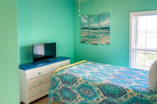 a bedroom with a bed and a tv on a dresser at Weatherbee by the Sea in St. George Island