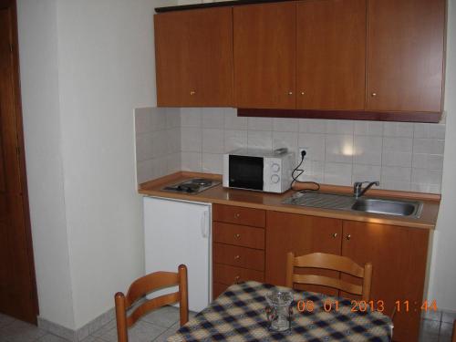 a small kitchen with a table and a microwave at Hotel-Apartments La Strada in Tycherón