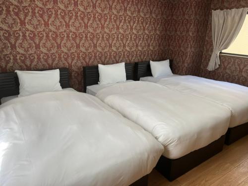 duas camas sentadas uma ao lado da outra num quarto em Parkside Inn Hakata No5 em Fukuoka