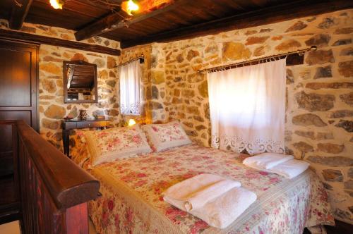 a bedroom with a bed with towels on it at Thalori Traditional Ecotourism Village in Kapetanianá