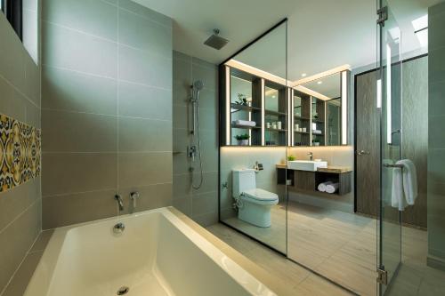 a bathroom with a tub and a toilet and a shower at Citadines Prai Penang in Bukit Mertajam