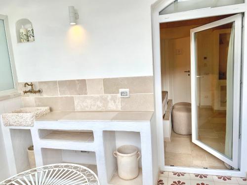 a small bathroom with a sink and a mirror at Vittorio Emanuele Charming Suites in Monopoli