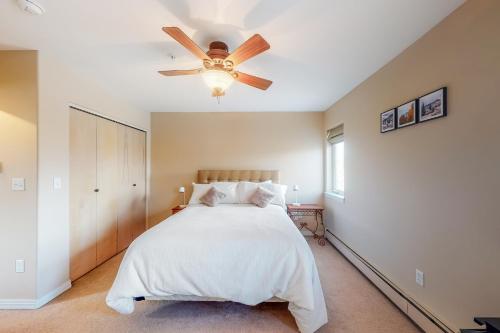 a bedroom with a white bed with a ceiling fan at At the Crossroads in Frisco