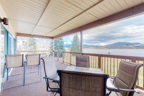 a screened porch with chairs and a table with a view of a lake at Lakeside Mountain Retreat in Dillon