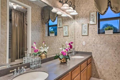 a bathroom with two sinks and a large mirror at Lavish Escape with Game Room - 20 Mi to Beach! in Palm Beach Gardens