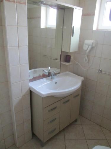 a bathroom with a white sink and a mirror at Residence la Piazza in Santa Maria