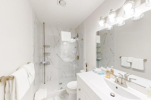 a white bathroom with a sink and a shower at The Cubby at Prospector in Park City