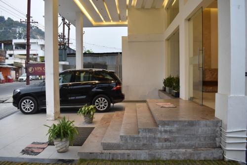 a black car parked outside of a building at Hotel VPS Grand in Palani