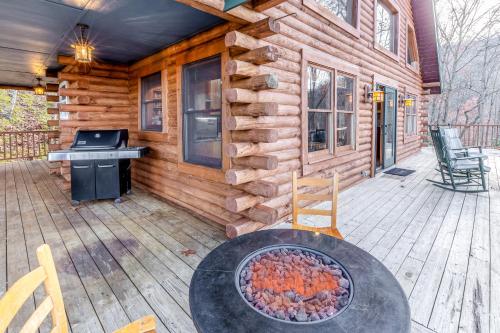 a log cabin with a grill on a patio at Cloud Walk in Sylva