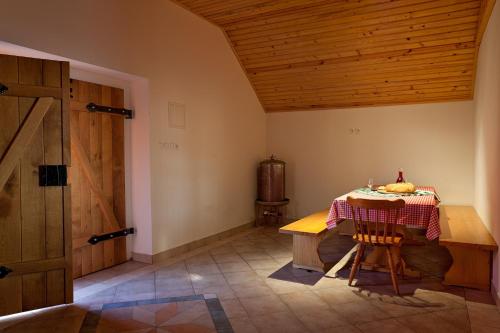 a dining room with a table and a wooden ceiling at Vineyard Cottage Ucman in Otočec